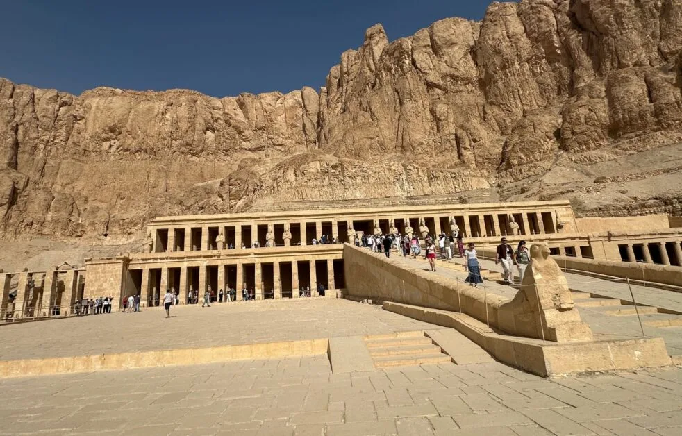 Stone walkway leads to the Temple of Hatshepsut, with grand columns built into a cliff side.