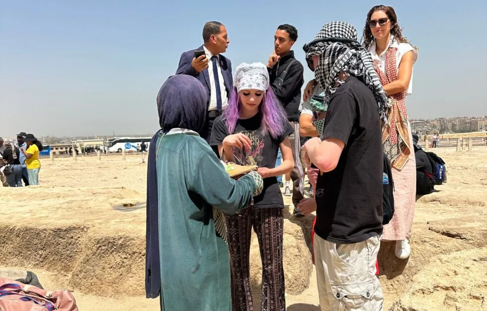Teens bartering for souvenirs at Giza Pyramid.