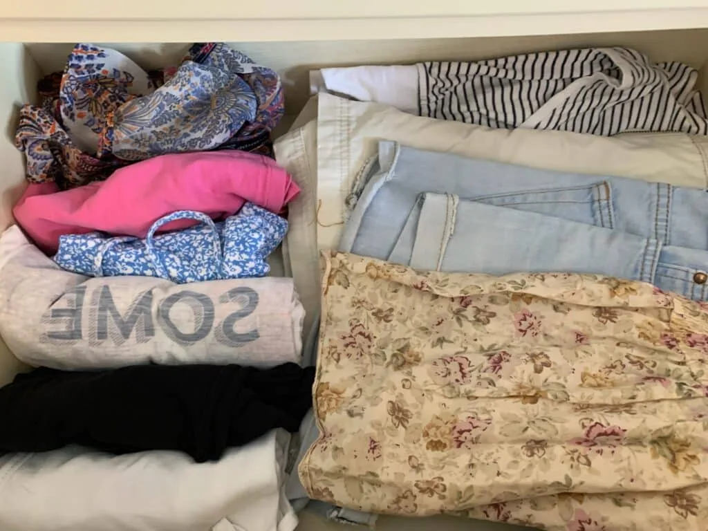Photo shows clothes rolled to fit into hand luggage on a plane.