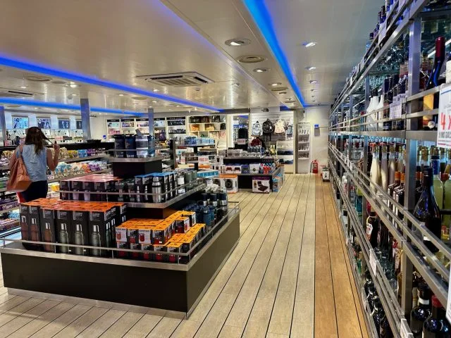 Duty-free shopping on a ferry showing bottles of alcohol for sale.