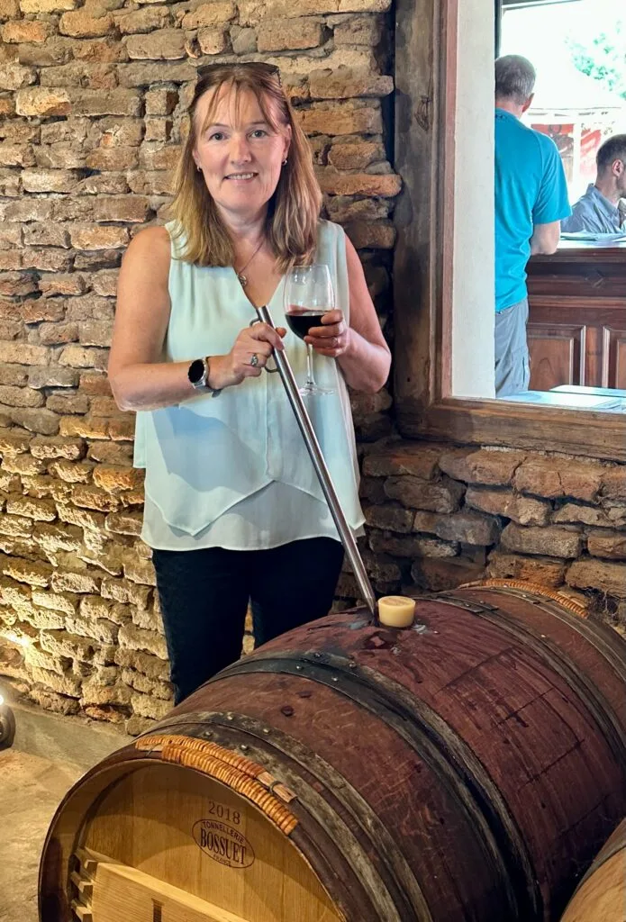 Hand-drawing wine from a barrel.