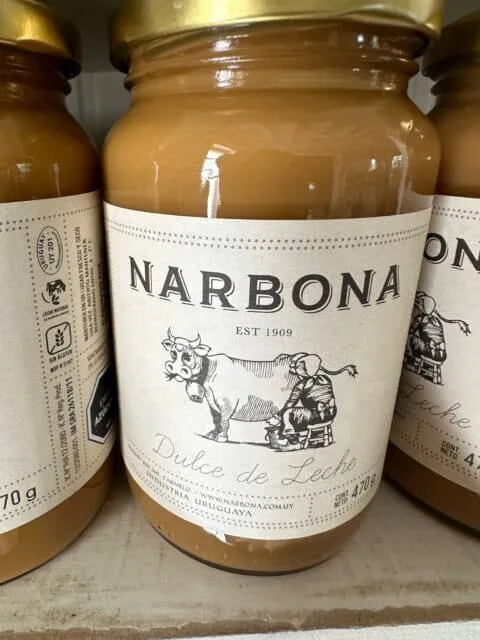 A glass jar with a cow on the front advertises a brand of dulce de leche.