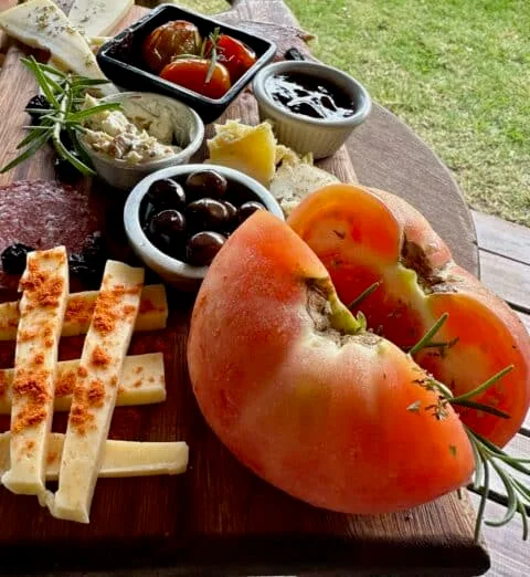 3-day itinerary in southwest Uruguay. Tomatoes, cheese, and olives are served on a wooden platter.