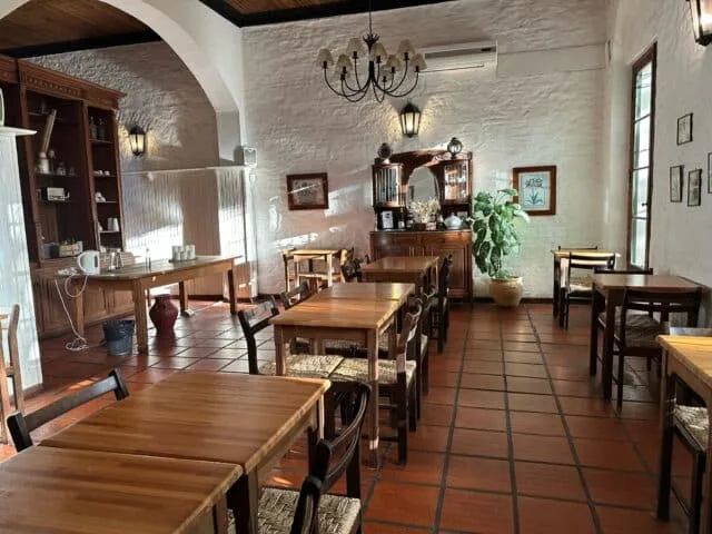 Dining Room of a hotel with tiled brown floor and traditional wooden furniture