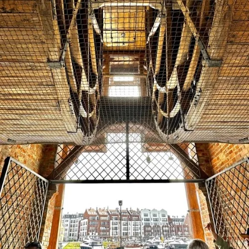 Metal cages protect 5m wide wooden wheels used to operate the crane encased around it. Medieval engineering.