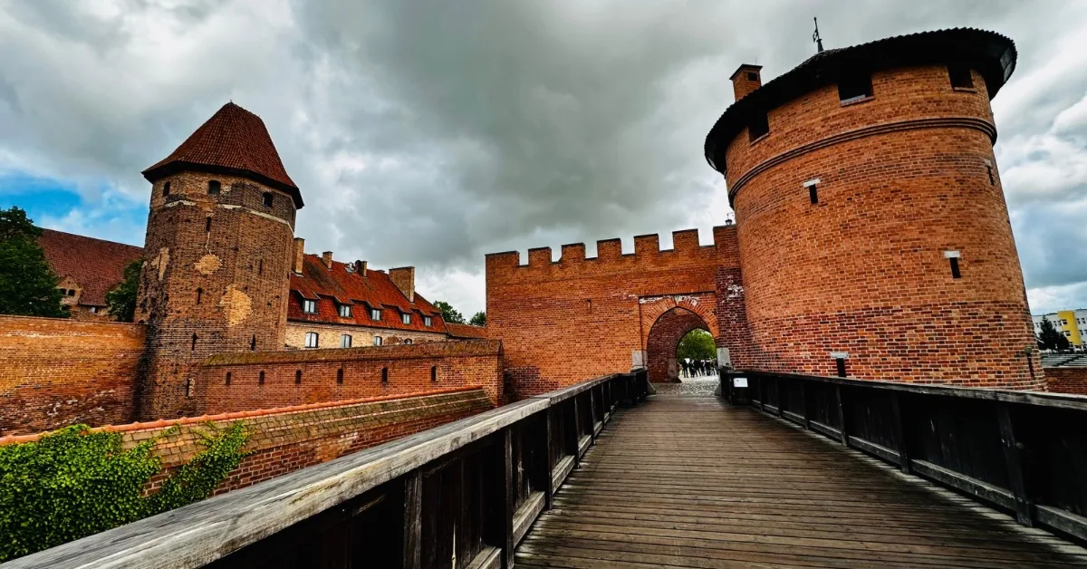 Red brick round towers and drawbridge entry way to a castle near Gdansk Poland.