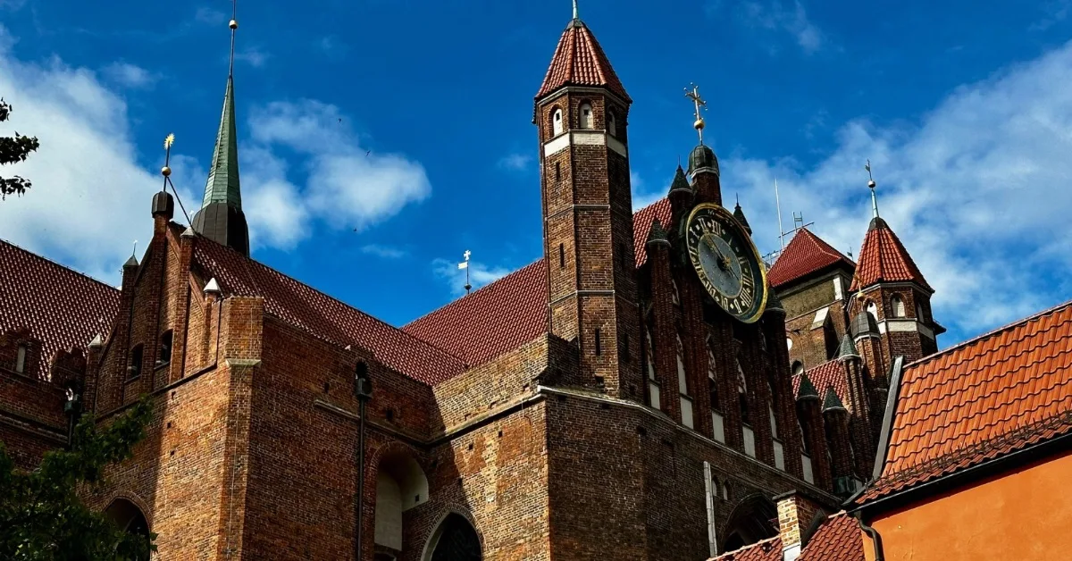 Several church spires and red roof tiles of churches in Gdansk Poland.