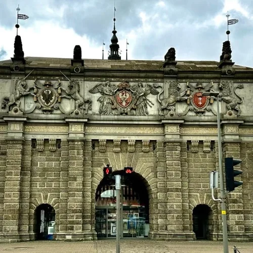 Stone arched building with coats of arms and statues in Gdansk Old Town.