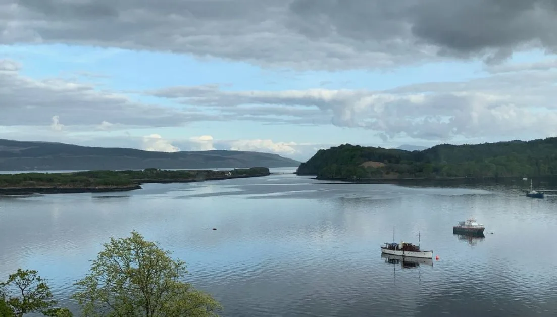 A sheltered bay in Scotland with a small boat anchored.