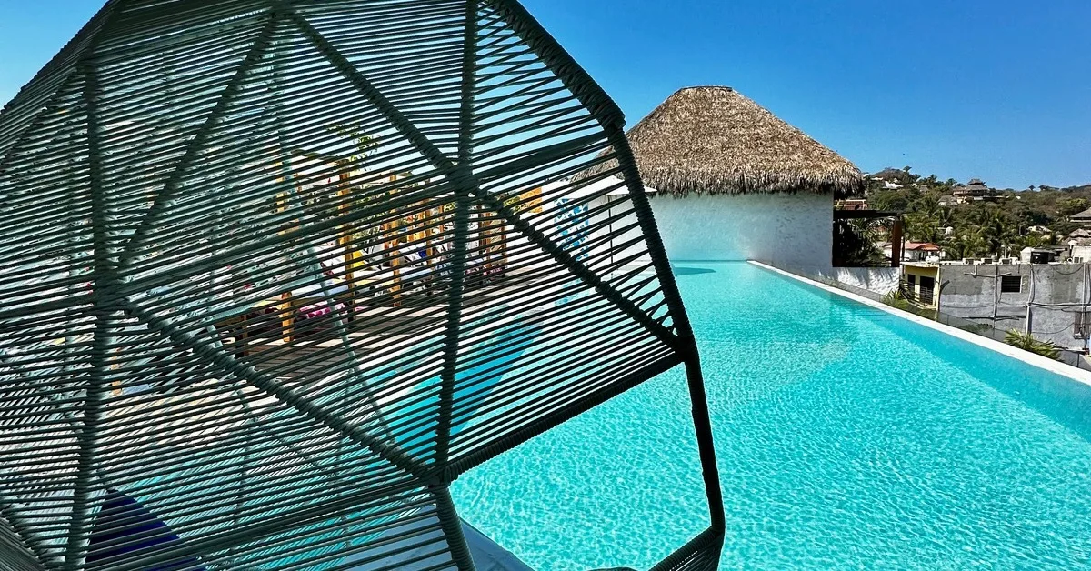 Hanging chair over a rooftop pool area.