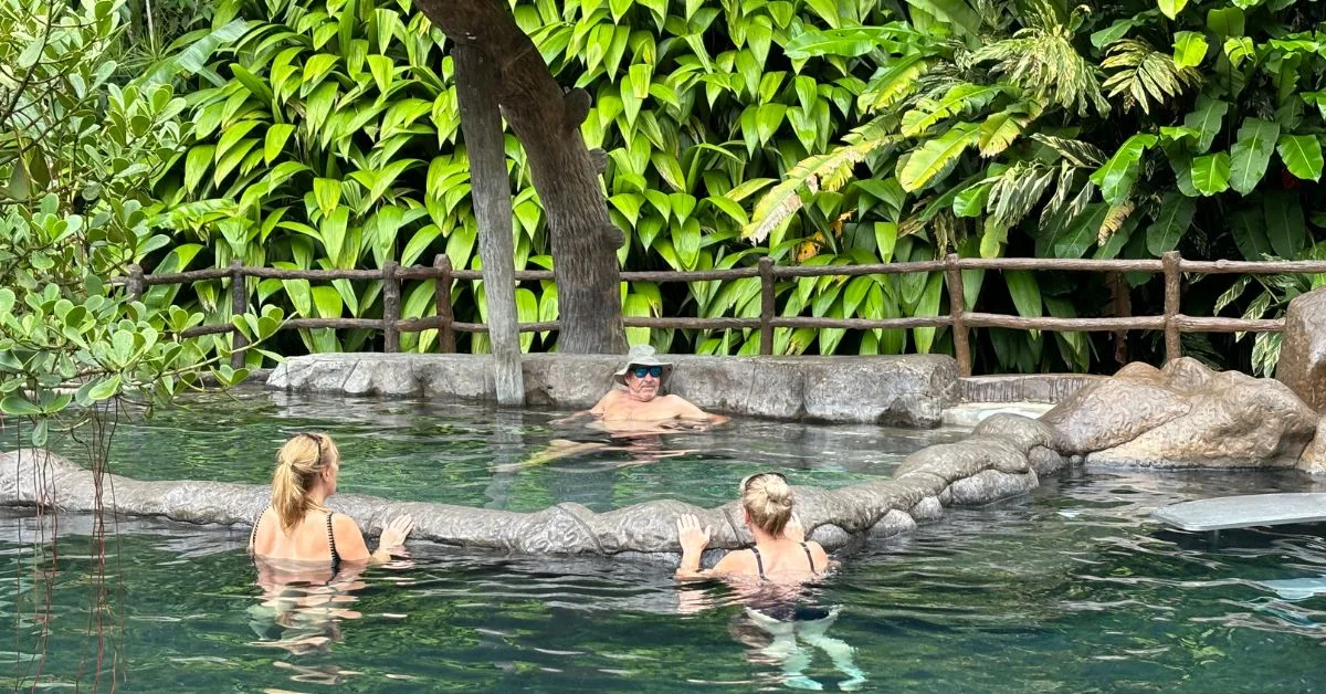 Three people bathe in hot water springs