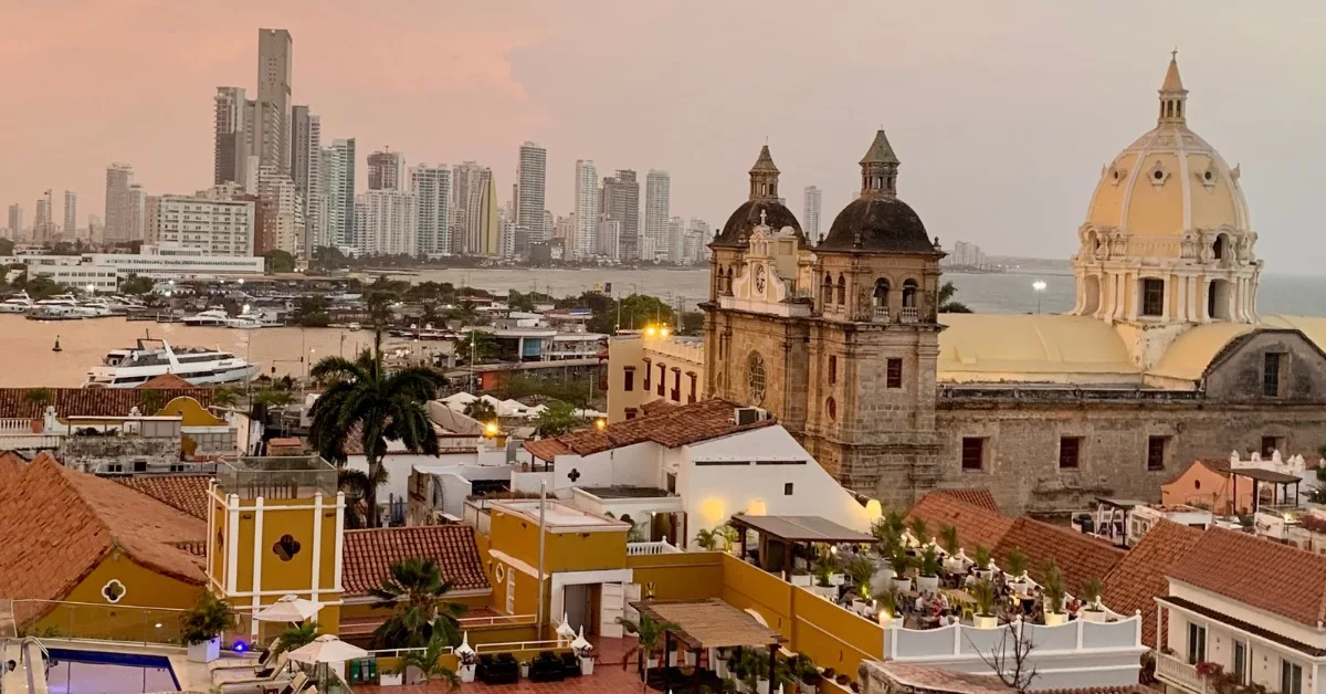 View of old town rooftops and modern Cartagena skyscraper buildings at sunset.