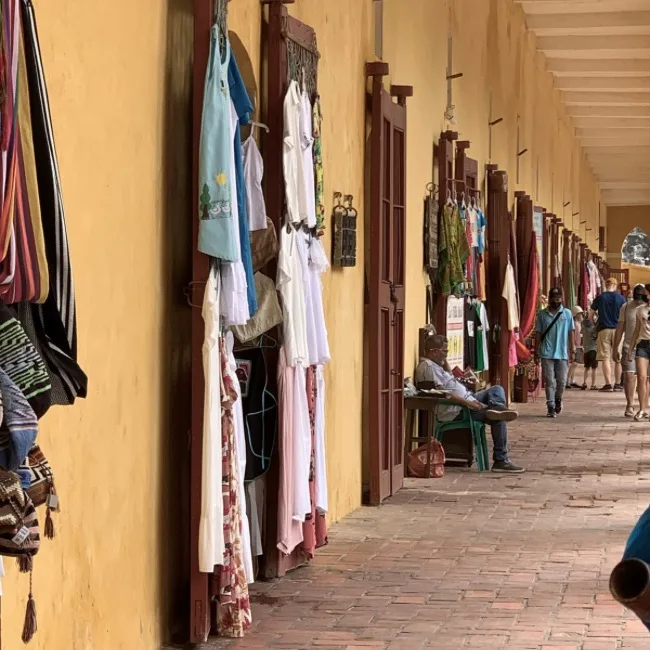 Rows of souvenir shops with items hanging outside doorways.