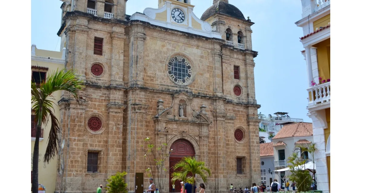 Red Brick building with clock and ornate round windows in city of Cartagena.