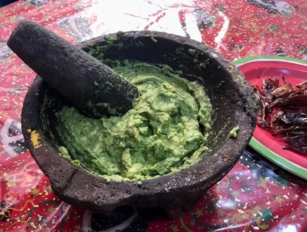A stone dish full of freshly made guacamole.