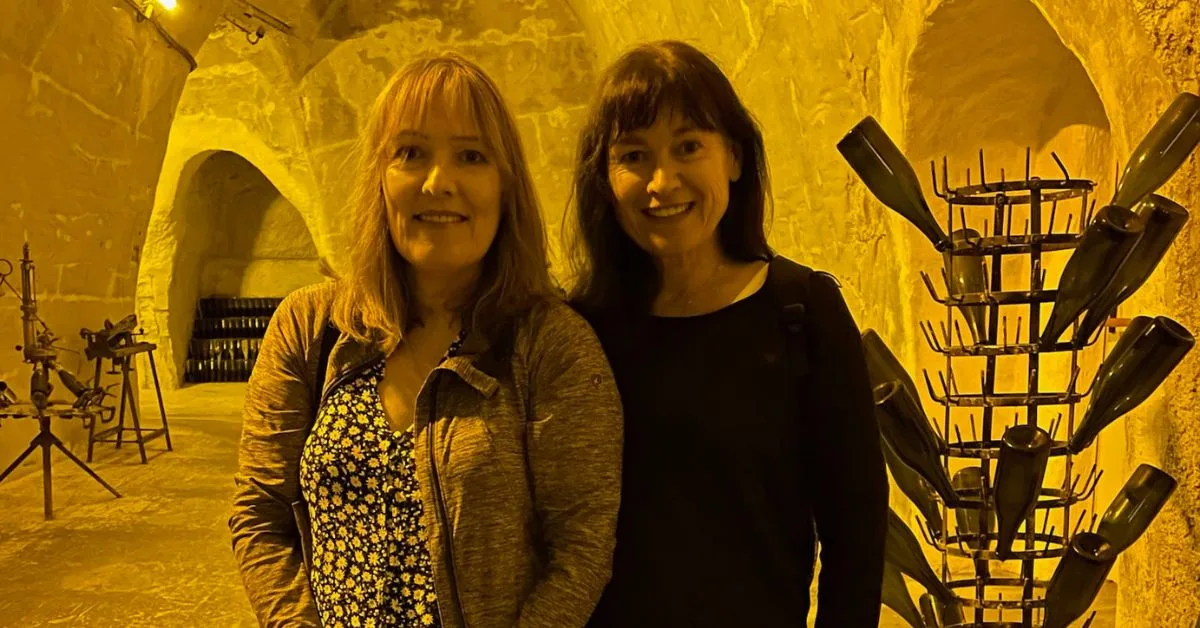 2 women inside a chalk cave used for storing champagne.