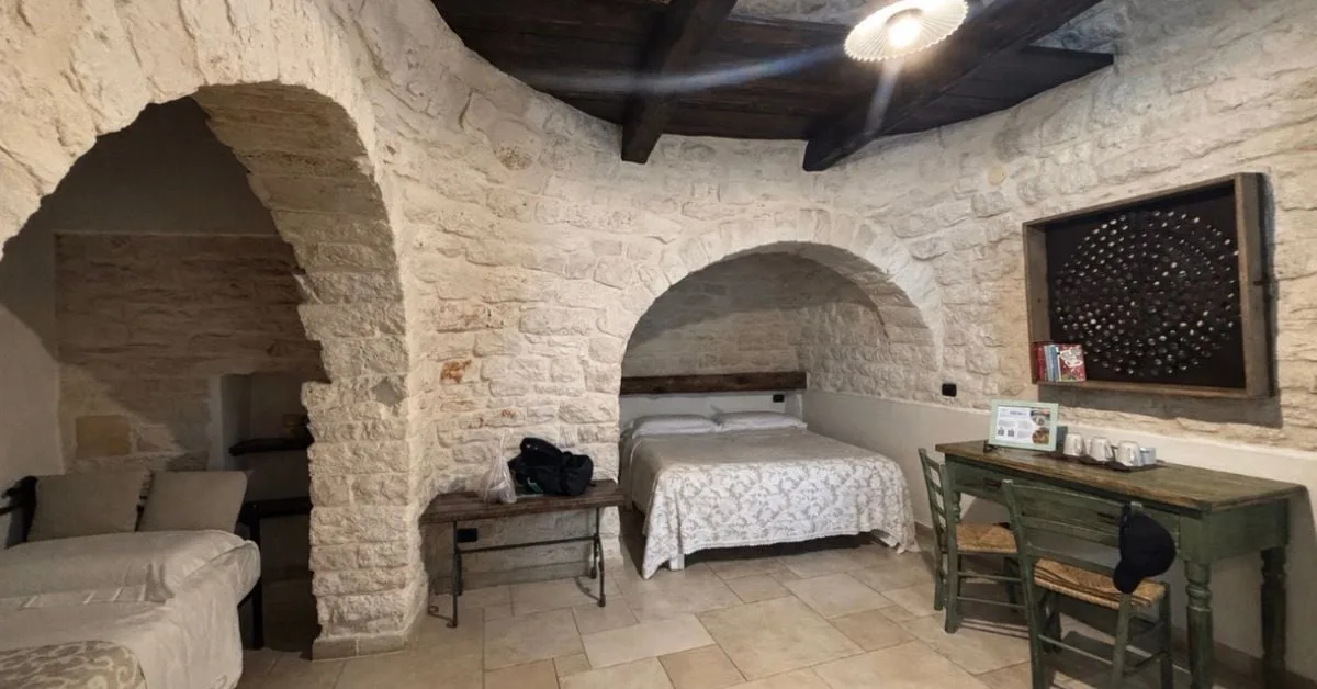 Interior of a trulli bedroom in Alberobello — traditional stone walls and cosy furnishings