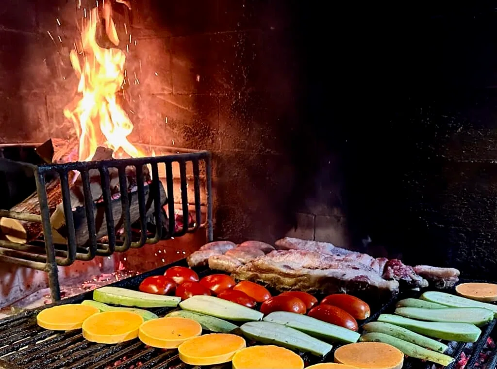 Traditional Asado in Mendoza. Meats and vegetables are on a wood fired grill.