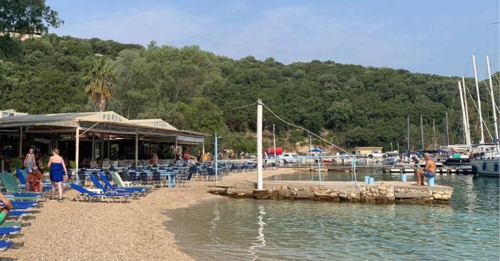 Small quiet beach area with sunbeds, a restaurant and boats bobbing