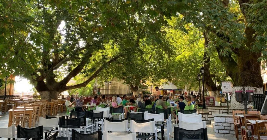 Large open square outdoors for casual dining and mature trees sit within the square and dining area