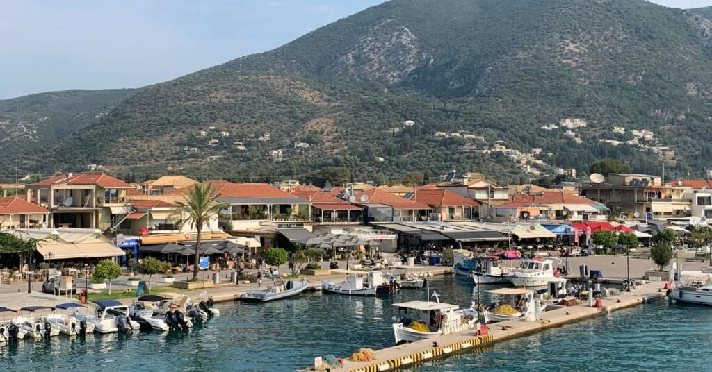 Harbour area of Nydri with red roofed houses and restaurants in the background and boats in the harbour