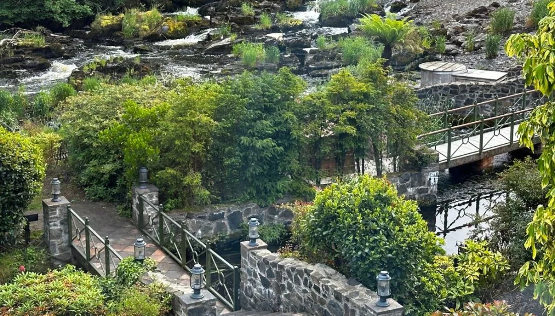 Stone walkways, a flowing river and fully blooming shrubs and trees, open to guests at Galgorm Resort.