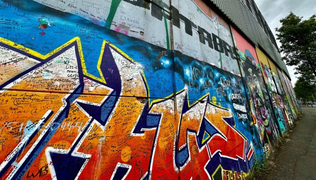 A mural in Belfast with multi-coloured images. Known as Peace Wall, people have left messages on the wall.