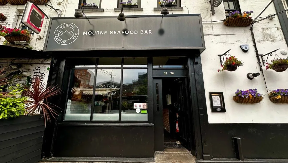 Frontage of Mourne Seafood Bar Belfast with hanging flower baskets decorating the external walls.