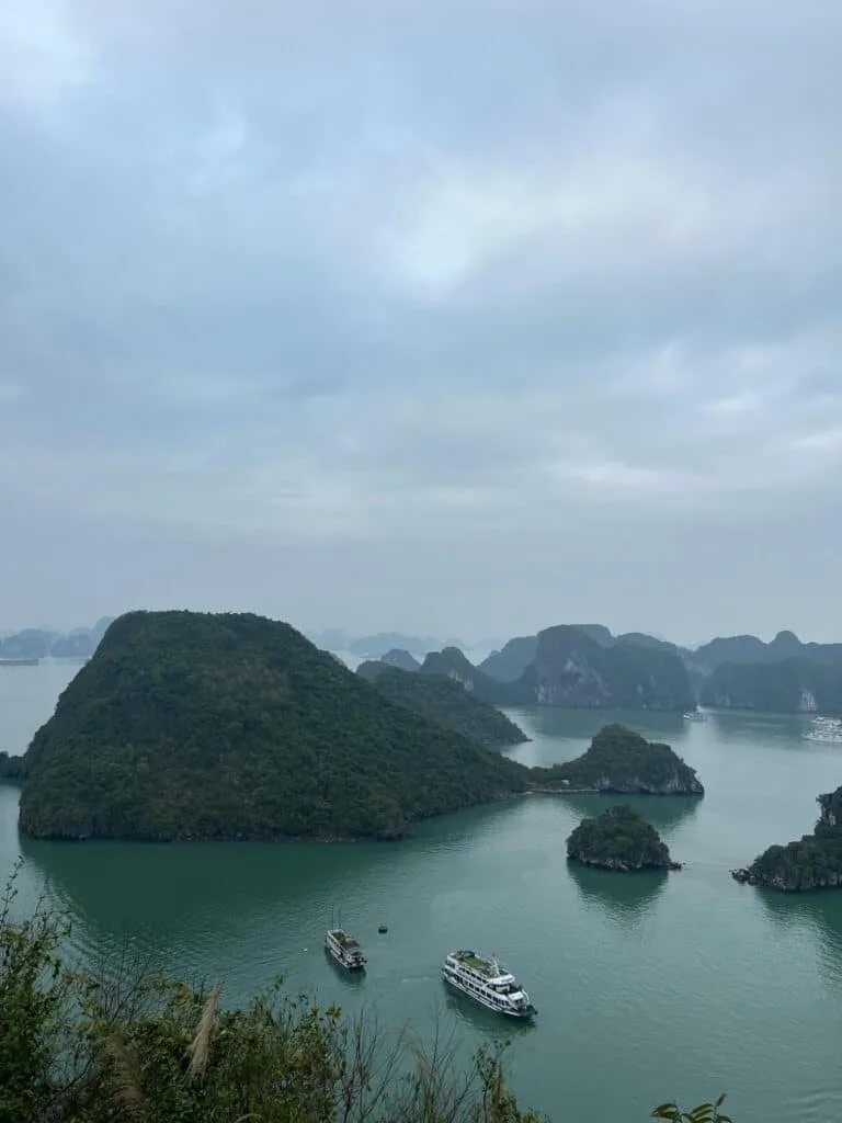 Small islands jutting from the waters with some boats anchored in the bay