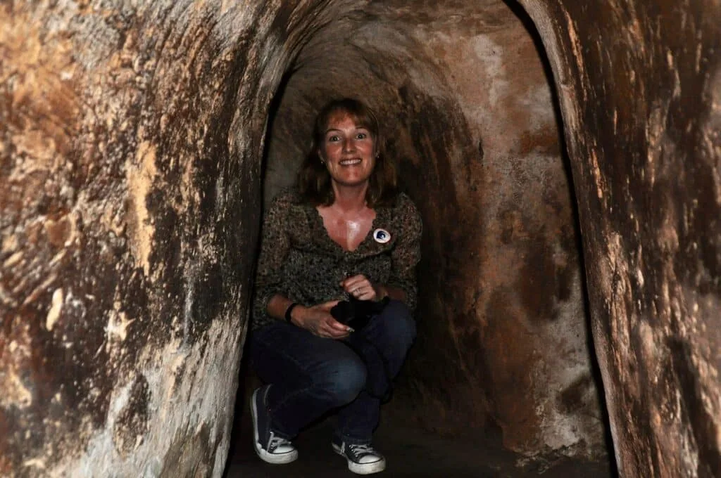 Tourist inside the chi chi tunnels which are no more than 3-4 feet high and very narrow. People hid here during the war.
