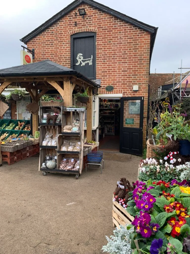 Boxes of produce are displayed outside of a village store.