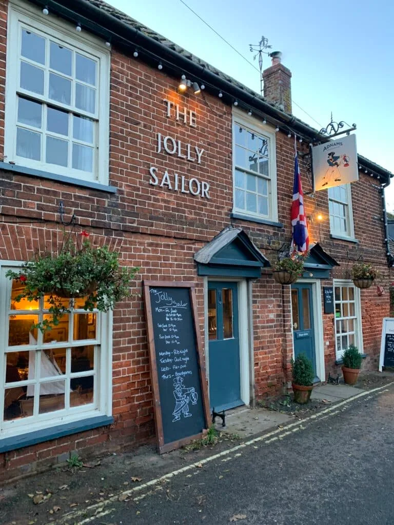 A traditional pub called the Jolly Sailor with a sign showing daily specials outside.