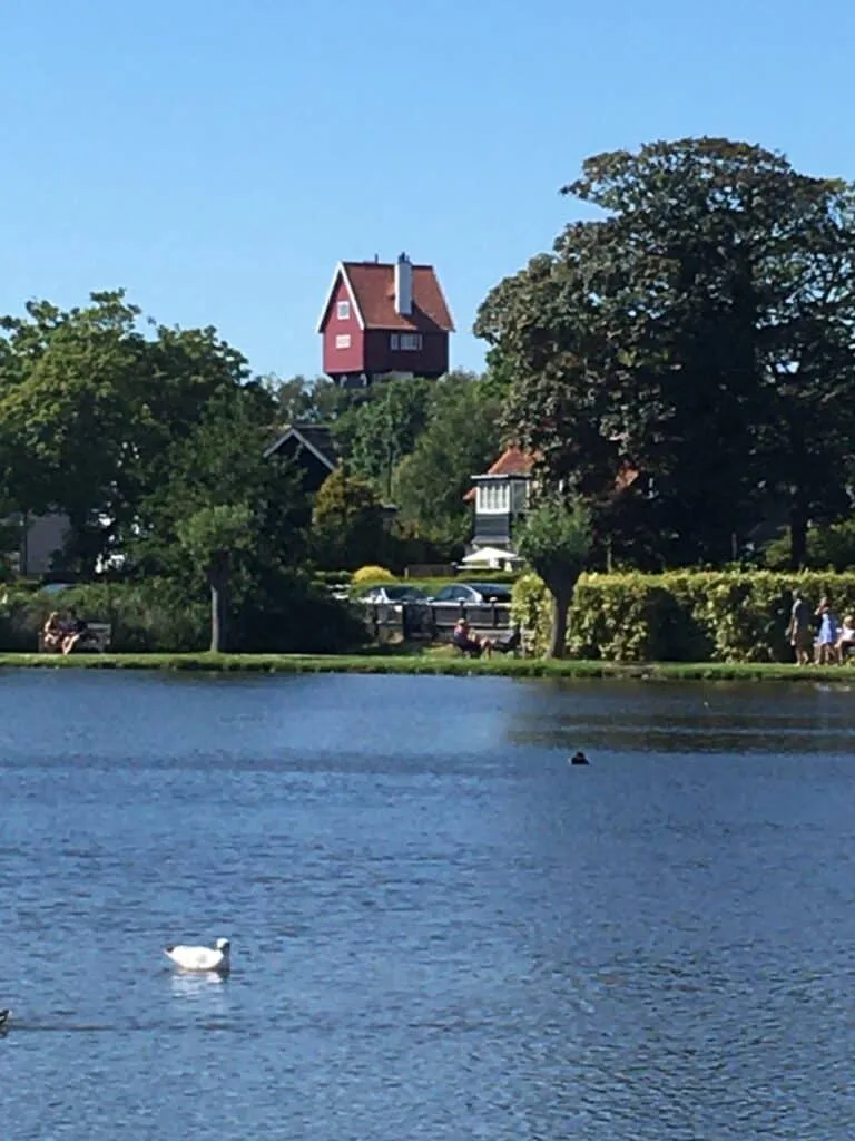 A disguised water tower stands tall in the vista over a lake. The water tower is now a hotel.