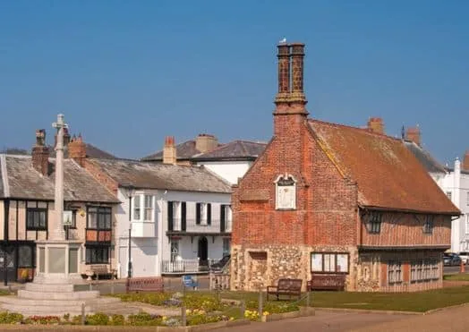 A red brick building which served as a town hall with a tall chimney.