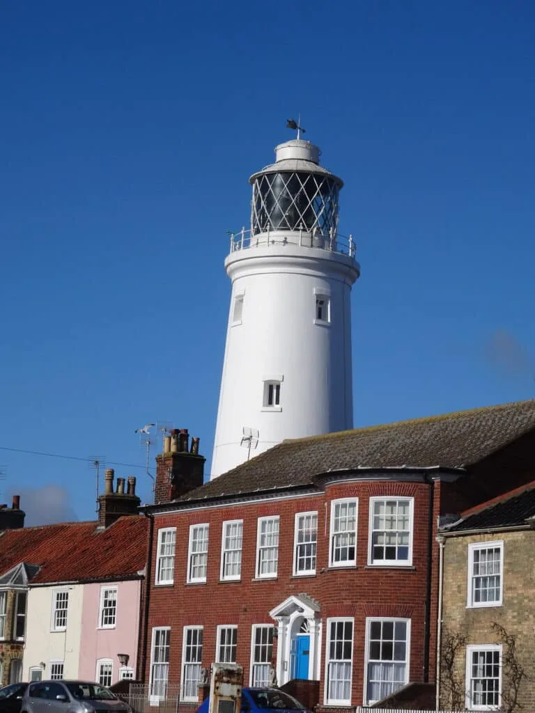 A white washed lighthouse with light glass area at the top in the town of Southwold Suffolk
