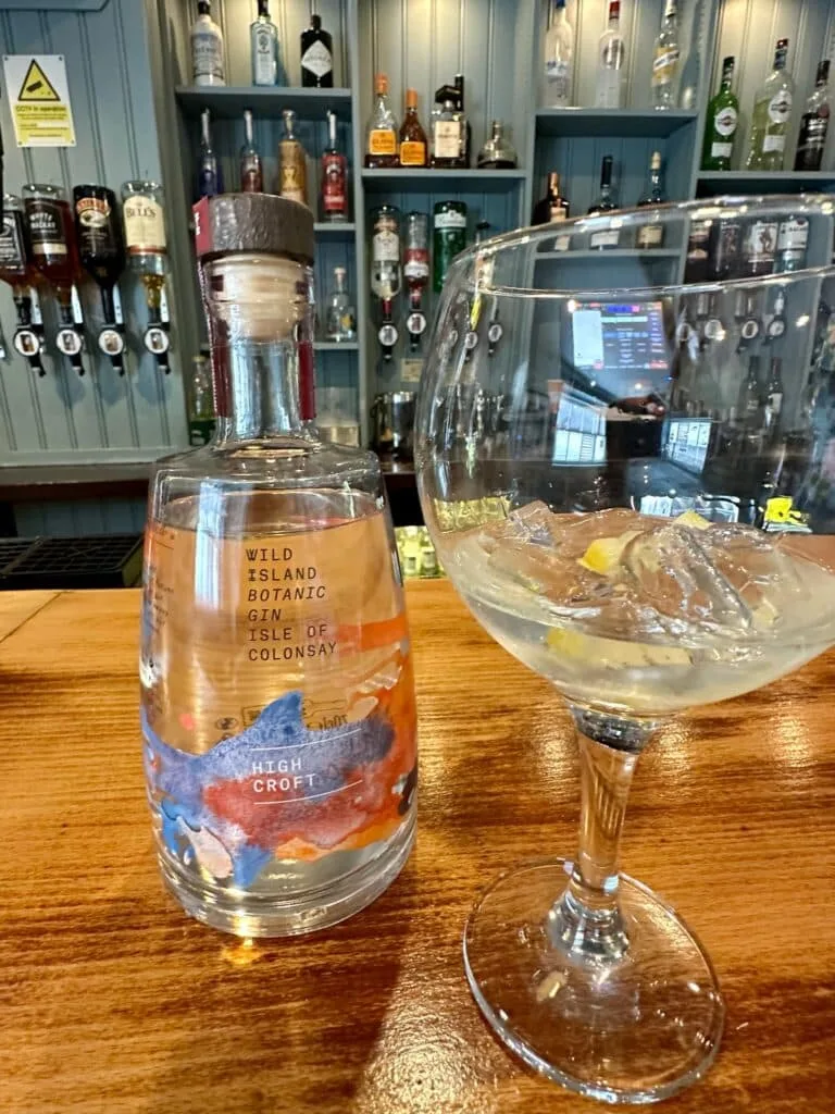 A bottle and glass of island botanical gin made on Colonsay,