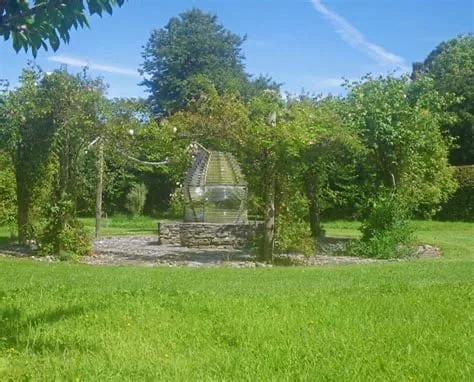 Colonsay Gardens a wishing well surrounding by rose bushes and grass area