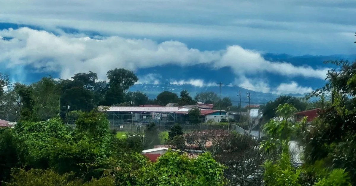 Central Valley Costa Rica mountains with low cloud cover. The town of Alajuela is visible below the clouds.