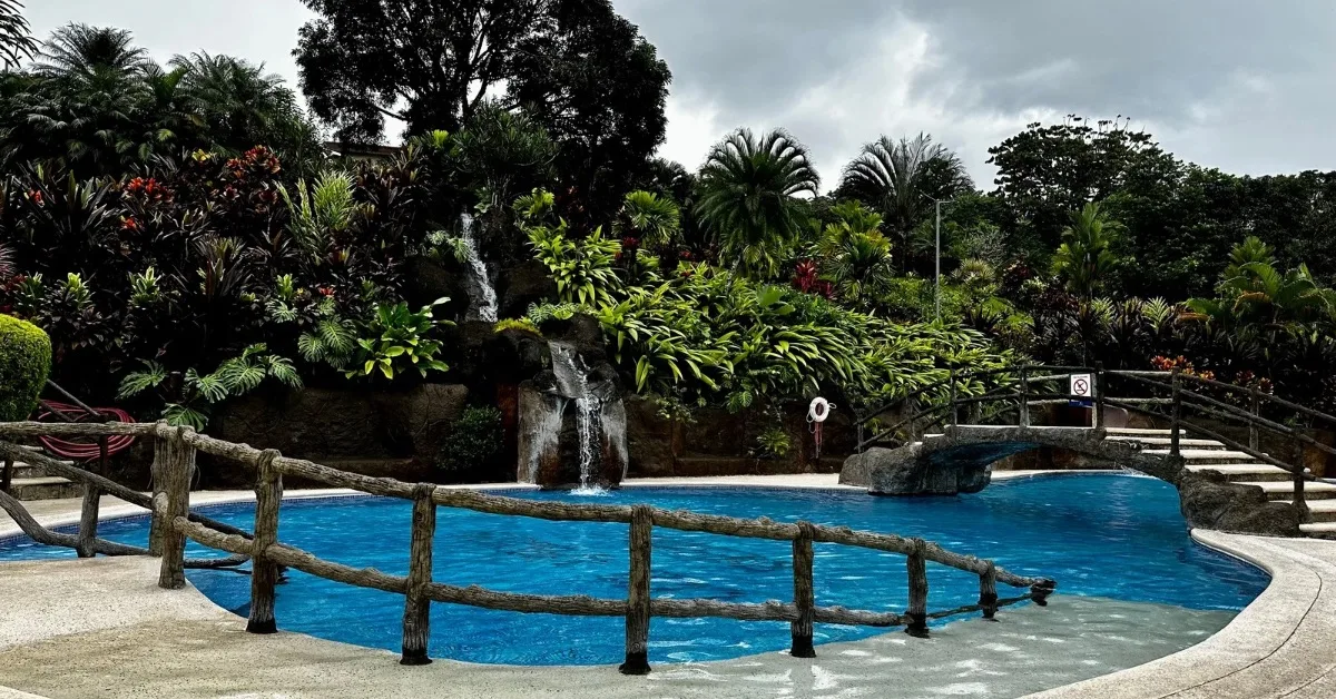 Swimming pool surrounded by trees and flowers at Los Lagos Resort La Fortuna Costa Rica.