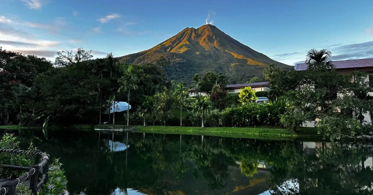 View of Arenal Volcano from the grounds of Los Lagos Resort near La Fortuna. Blue skies reveal the puff of smoke from the volcano peak.