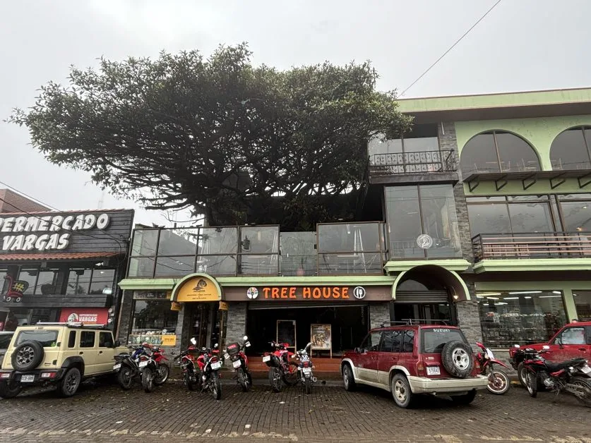 Street in Santa Helena Costa Rica with bikes and cars parked outside Tree House Restaurant.