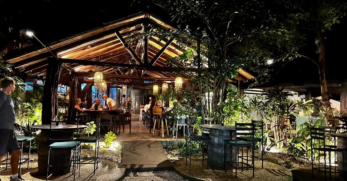 Outdoor restaurant with round tables and a central A frame covered area for guests.