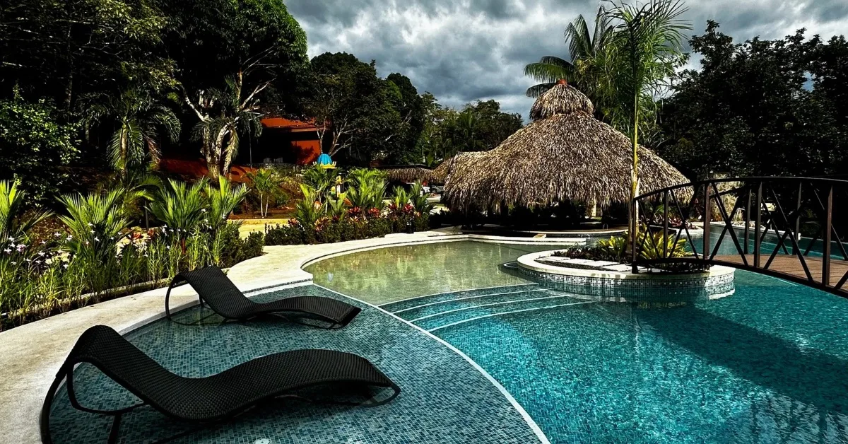Pool and sun loungers within a garden at Poza Blanca Lodge in Costa Rica.