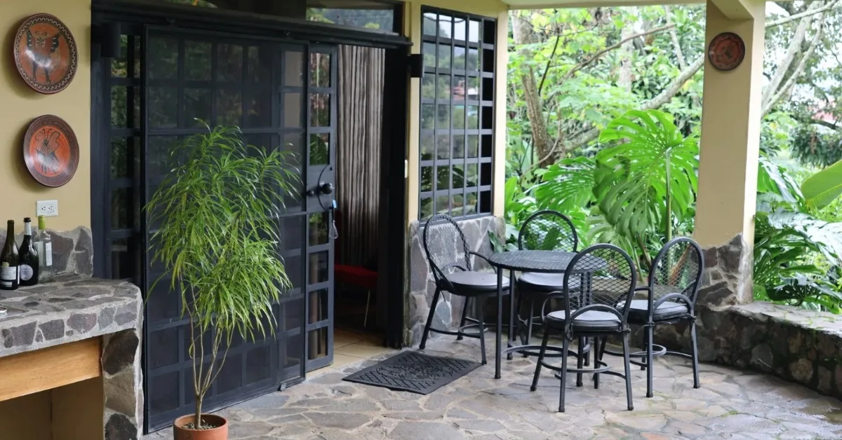 Outdoor Patio area with table and chairs and outdoor kitchen is part of a room at Pura Vida Hotel in Alajuela Costa Rica.