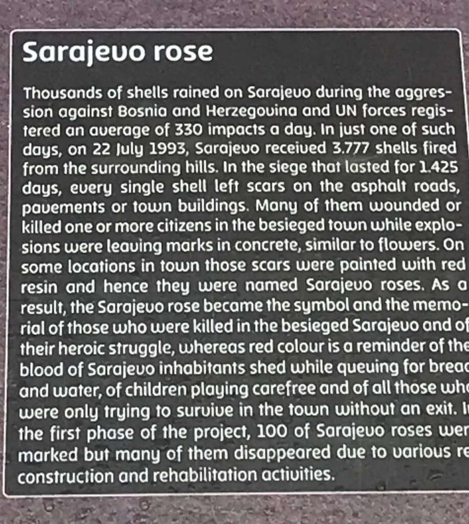 A plaque explaining the red splatters (roses) scattered around the city of Sarajevo.