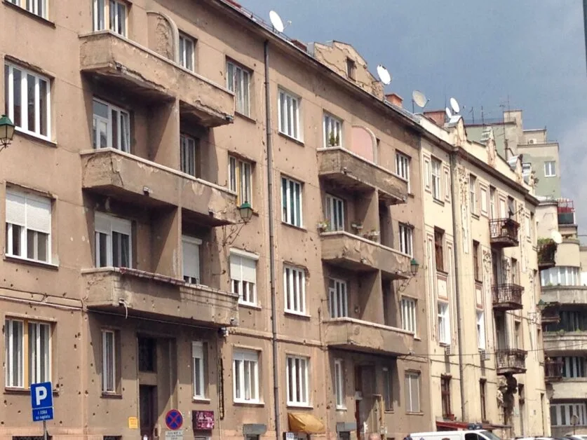 Bullet holes are visible on the external walls of an apartment building on Snipers Alley in Sarajevo.