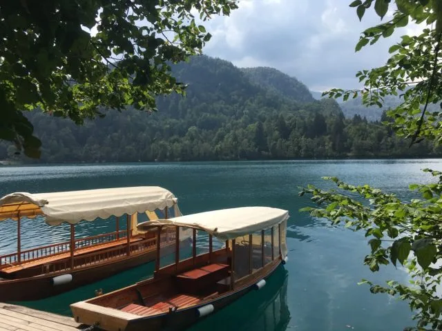 Two wooden boats with overhead canvas shade sit waiting for tourists.