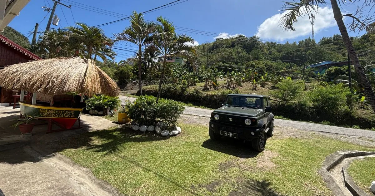 Jeep parked up outside a cafe in the countryside of St Lucia with palm trees and blue skies in the image