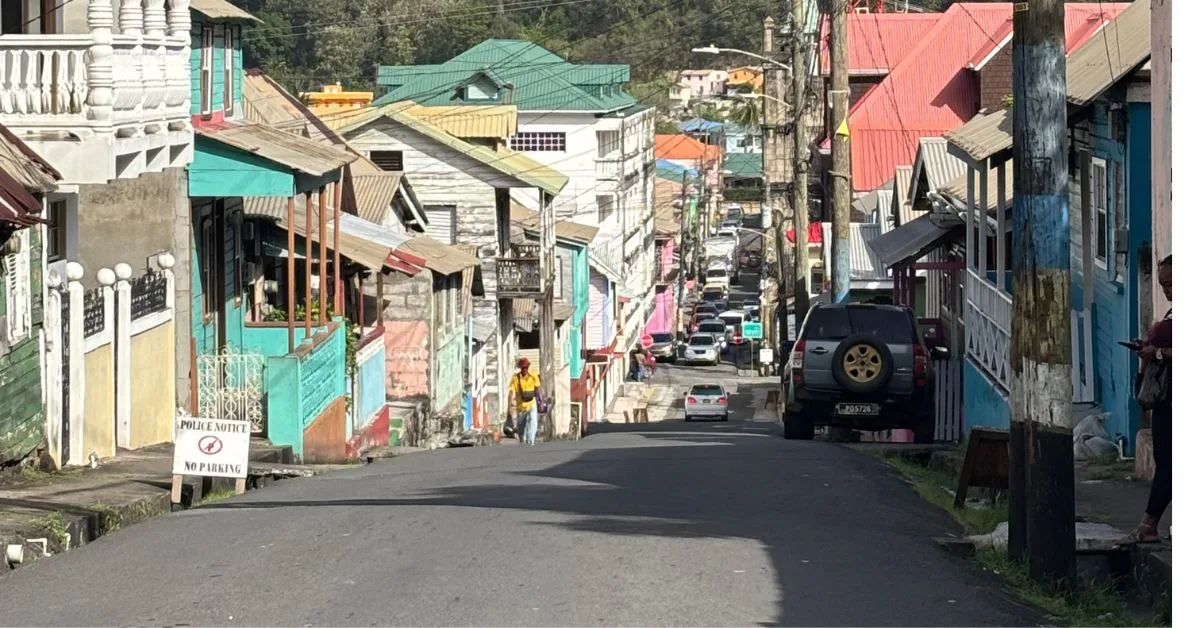 Narrow but colourful street in Soufrière  showing houses either side of the steep road.