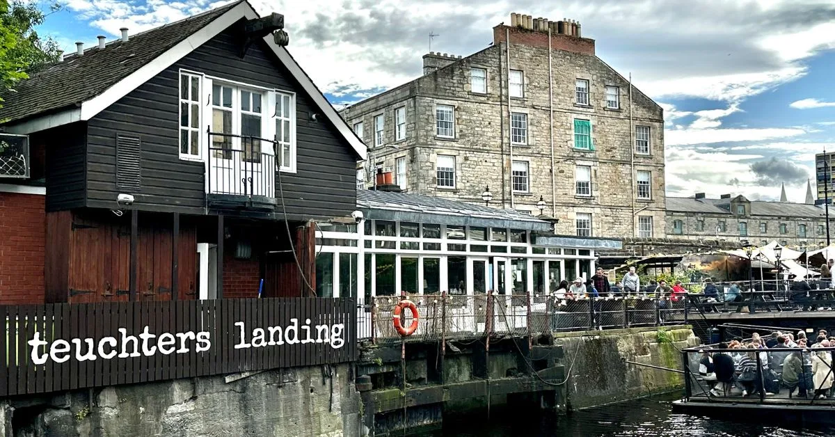 People are sitting outside a waterfront pub in Edinburgh.